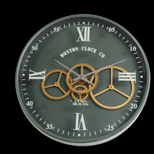 A round, wall-mounted clock with a green background, featuring Roman numerals, a central gear mechanism and the Boston Clock Co. branding.