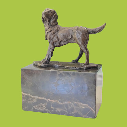 A solid bronze sculpture of a Spaniel dog mounted on a marble base.